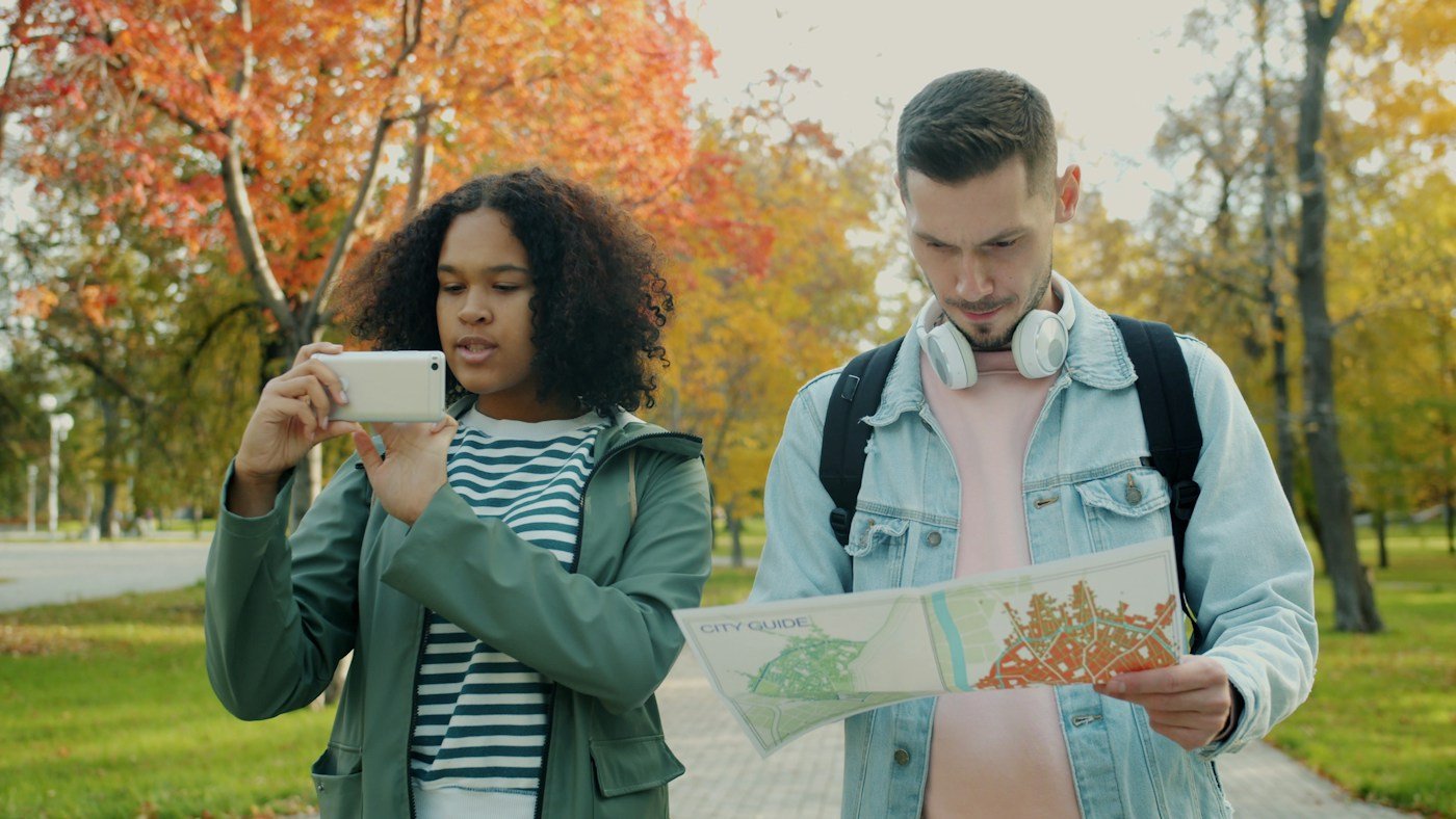 Two travellers checking a map and phone