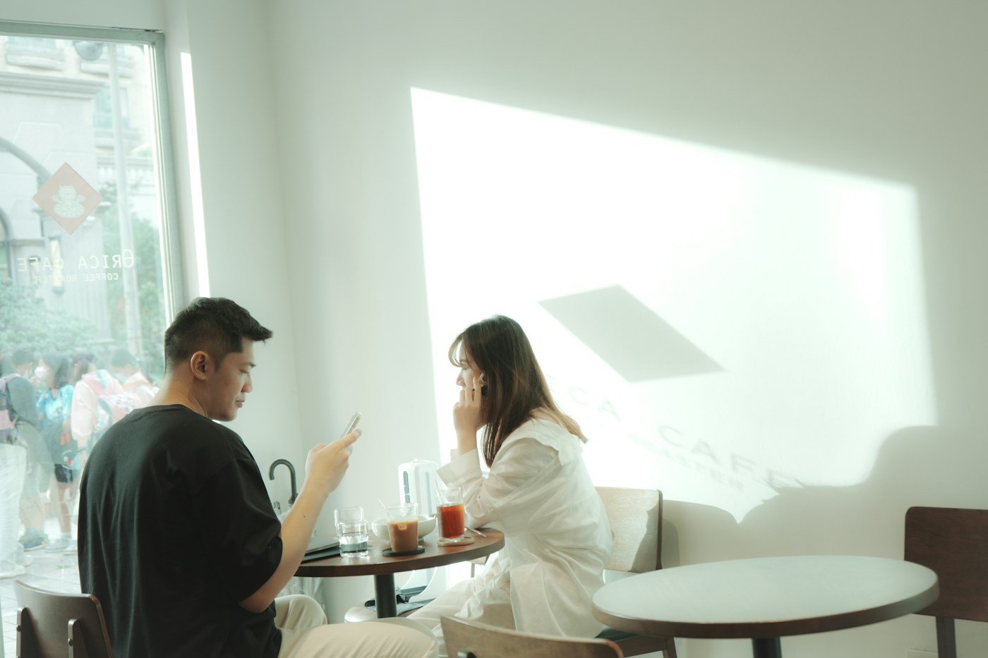 Two adults talking at a table by a window